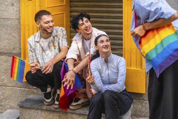 Group of diverse friends expressing joy and belonging, holding rainbow flags and carrying a rainbow bag, celebrating gay pride and lgbtqia plus inclusion in a city environment
