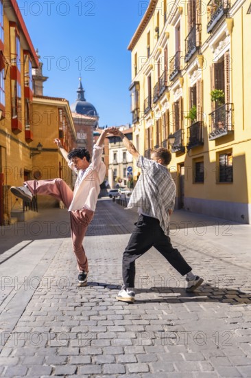 Two energetic young men performing a street dance on a cobblestone street in a lively european urban setting under clear blue skies, expressing creativity and freedom