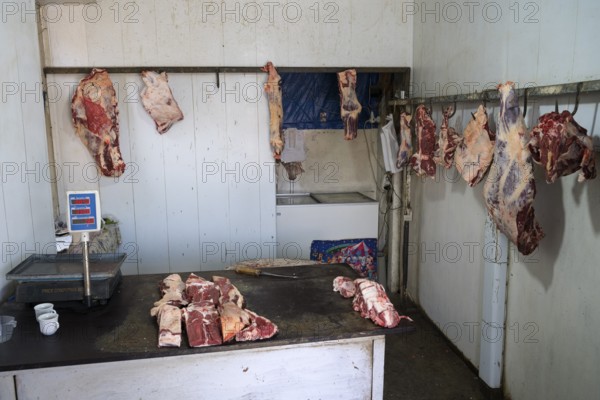 A butcher's room with pieces of meat on hooks and a table with scales, Martuni, Gegharkunik province, Armenia
