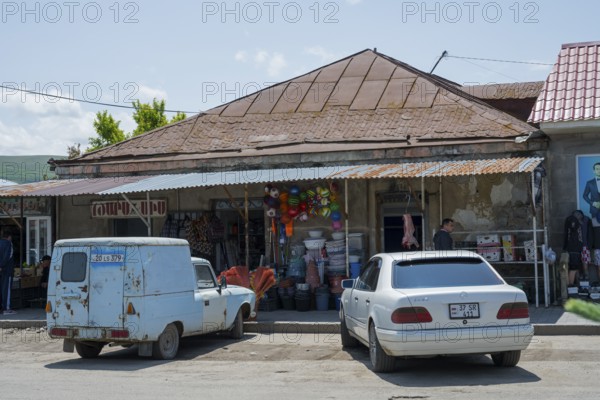 A rustic shop with cars in front of it, in a rural street scene, Martuni, Gegharkunik province, Armenia