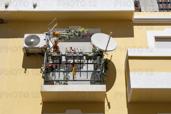 Small balcony with satellite aerial, air conditioning, terrestrial aerial, flower arrangements in a very small space, closed shutters, in Vila Real de Santo António, on the border with Spain, Algarve, Portugal