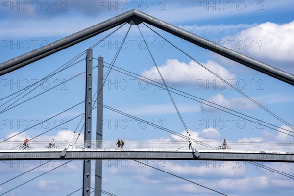 Bridges in Düsseldorf, in the foreground, the pedestrian and cycle bridge over the canal to the inner harbour, media harbour of Düsseldorf, behind it the Rheinkniebrücke, road bridge over the Rhine near Düsseldorf, Germany