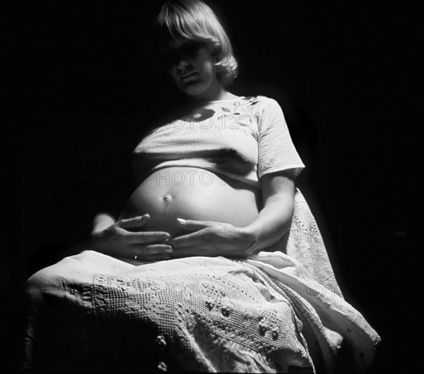 Pregnant woman with her hands on her belly, black and white, Bavaria, Germany