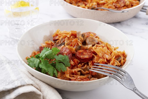Bigos, Polish dish bigos, on the table, pan with stewed meat, with cabbage, chorizo sausages, mushrooms, homemade, without people
