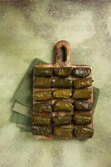 Dolma, minced meat with rice, in grape leaves, minced meat rolls, on a chopping board, top view, no people