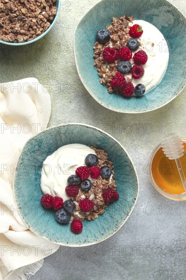 Breakfast, two bowls, yogurt, muesli with berries, and honey, homemade, no people