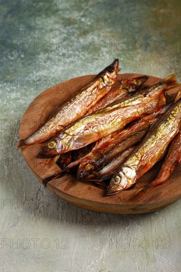 Cold smoked capelin, on a wooden bowl, top view, no people