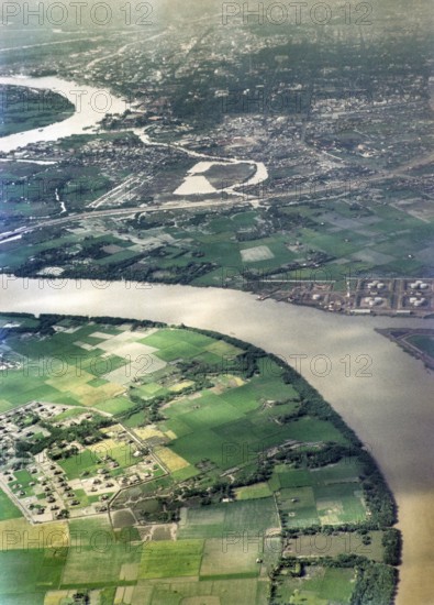 Captioned as 'aerial photo Saigon', meandering river in flat agricultural landscape of paddy fields, Vietnam, south east Asia c 1964