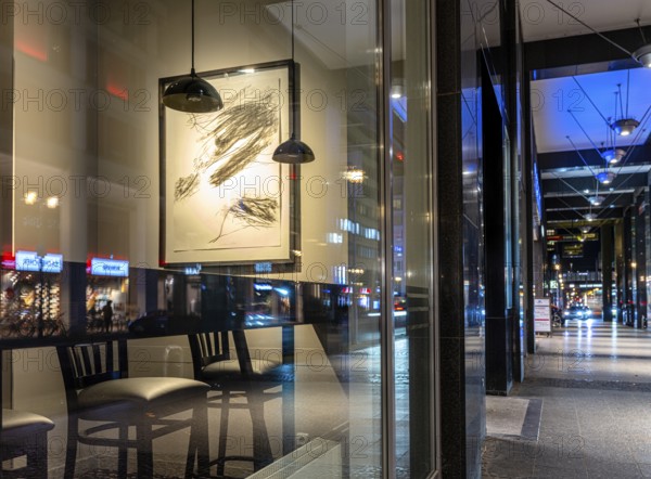 Urban scene in the evening with reflections of Friedrichstraße in the window pane of a bistro, Berlin, Germany