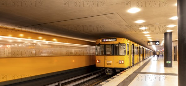 Dynamic scene of a Berlin underground in typical yellow colour, long exposure with blur effect, busy traffic junction at Unter den Linden station, Berlin, Germany