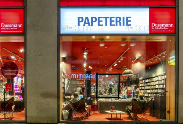 Dussmann GmbH, Bookstore, Urban scene in the evening with reflections in the window pane and a view of the displays and shelves, Berlin, Germany