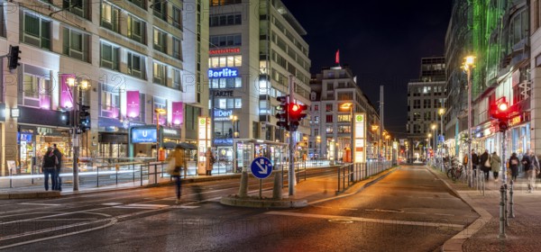 Night shot of Friedrichstraße at the railway station with a view of the tram stop and the commercial buildings along the pavements, Berlin, Germany