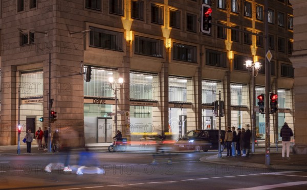 Night photo with long exposure and motion blur, pedestrians and vehicle traffic on the boulevard Unter den Linden, Berlin, Germany