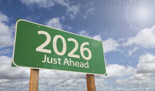 2026 just ahead green road sign over clouds and blue sky