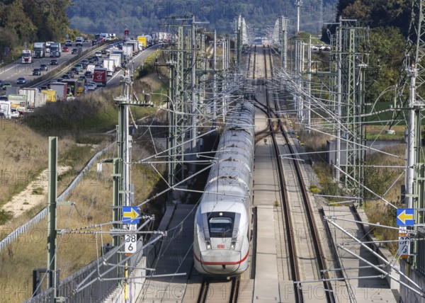 A8 motorway with traffic jam. The new high-speed railway line of Deutsche Bahn AG runs parallel between Stuttgart and Ulm. New railway line with Deutsche Bahn AG ICE with overhead lines and railway technology. Kirchheim unter Teck, Baden-Württemberg, Germany