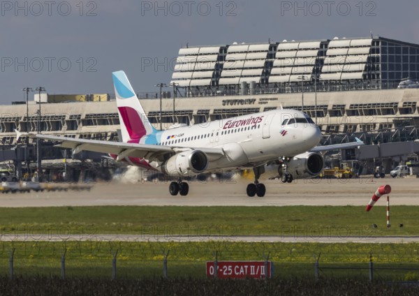Flight operations at Stuttgart Airport with terminal. Aircraft on landing. Aircraft registration number: D-AGWM, Eurowings, Airbus A319-100