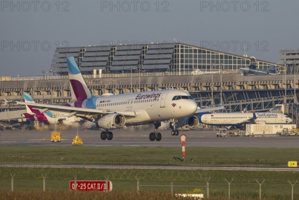 Flight operations at Stuttgart Airport with terminal. Aircraft on landing. Aircraft registration number: D-GAWX, EUROWINGS, AIRBUS A319-100, Stuttgart, Baden-Württemberg, Germany