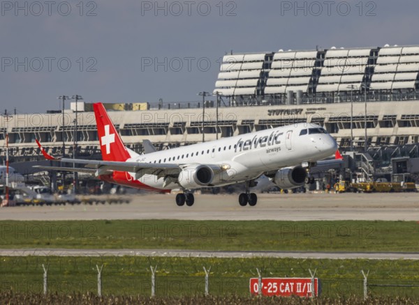 Flight operations at Stuttgart Airport with terminal. Aircraft on landing. Aircraft registration number: HB-JVZ, Helvetic Airways, Embraer ERJ-195, Stuttgart, Baden-Württemberg, Germany