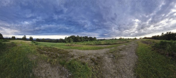 Vast landscape with dramatic clouds and a meandering path. Heaths and rough grassland nature reserve near Trupbach, Siegen