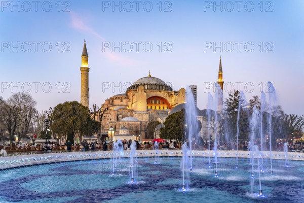 Fountain in Sultan Ahmet Park and the present-day mosque Hagia Sophia or Church of St Sophia at dusk, Istanbul, Turkey