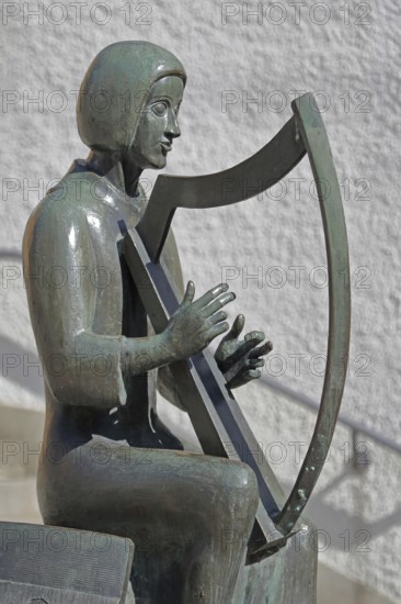 Sculpture Minnesänger von Wissenlo by the sculptor Hatto Zeidler 1978, monument, bronze sculpture, seated harpist, musician with harp playing, seated, Unterer Markt, Wiesloch, Baden-Württemberg, Germany