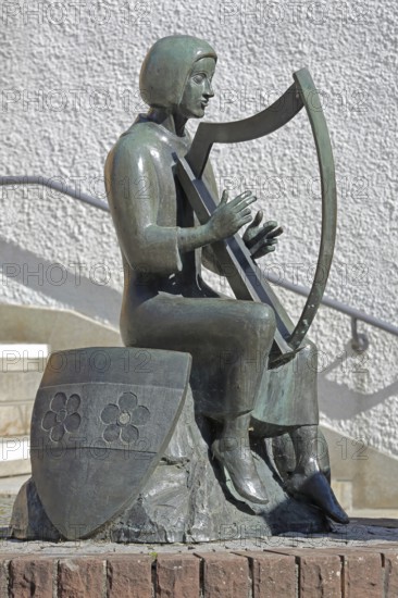 Sculpture Minnesänger von Wissenlo by the sculptor Hatto Zeidler 1978, monument, bronze sculpture, seated harp player with city coat of arms, musician with harp playing music, seated, coat of arms shield, Unterer Markt, Wiesloch, Baden-Württemberg, Germany