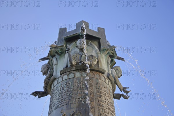 Town hall fountain by Klaus Ringwald 1998, bronze sculptures, reliefs, figures and text on the history of the town, inscription, water features, detail, cut-out, market square, Hechingen, Swabian Alb, Baden-Württemberg, Germany