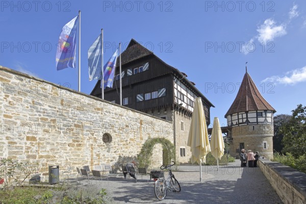 Water tower of the medieval Zollern castle built around 1255, half-timbered house, flags, stone wall, castle, Balingen, Swabian Alb, Baden-Württemberg, Germany