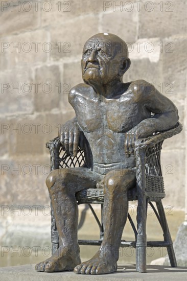 Sculpture The Old Man by Guido Messer 1981 bronze sculpture, modern art, old naked sitting man with angry facial expression, male figure, naked, angry, grumpy, bad-tempered, emotion, town church, Balingen, Swabian Alb, Baden-Württemberg, Germany