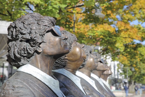 Sculpture Persil bleibt Persil by Guido Messer 1993, five bronze sculptures look synchronously up into the air, look, up, look, see, sunglasses, crossed arms, row, series, cheerful, joy, curious, faces, depth of field, autumn, Friedrichstraße, Balingen, Swabian Alb, Baden-Württemberg, Germany