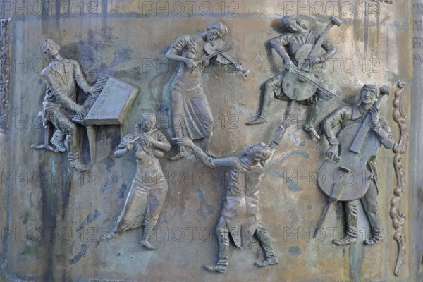 Relief with musicians at the town hall fountain by Klaus Ringwald 1998, modern art, six five, bronze sculptures, chamber music, piano player, flute player, violin player, cello player, double bass player, violin, cello, double bass, flute, quintet, conductor, make music, music group, musician, string instruments, town history, market place, Hechingen, Swabian Alb, Baden-Württemberg, Germany