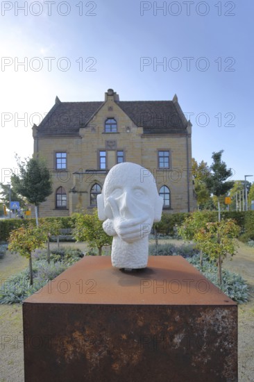 Sculpture head with headphones and hand for in front of the mouth, ambivalent symbolism for peace, silence and listening to music, no, not, communication, being alone, speaking, listening to music, music, listening, listening, mouth protection, hearing protection, contradiction, contradictory, house, Zollerschule, Hechingen, Swabian Alb, Baden-Württemberg, Germany