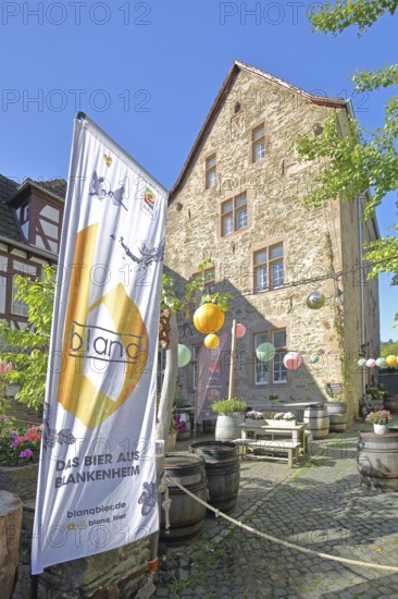 Banner with beer brand, lanterns and courtyard with wine barrels, flag, inscription, Blankenheim, beer brand, advertising, decoration, Steinfelderhof, Bad Münstereifel, Ahrgebirge, Eifel, North Rhine-Westphalia, Germany