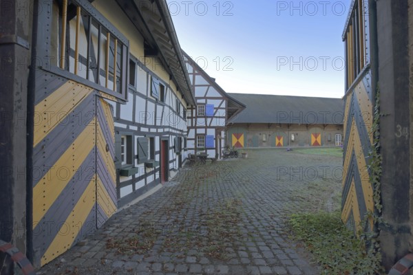 Portal and half-timbered house with colourful shutters, built 14th century, inner courtyard, archway, entrance, moated castle, Kleeburg, Weidesheim, Euskirchen, Vordereifel, Eifel, North Rhine-Westphalia, Germany
