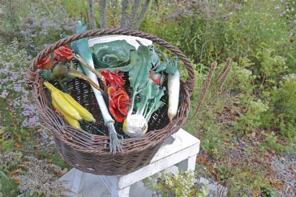 Sculpture market basket with chair by Thomas Schmidt, modern art, metal design, metalworking, real replica, steel sculpture, various mixed fruit and vegetables, fruit basket, fruit, bananas, kohlrabi, kale, leek, tomato, radish, roses, wicker basket, shopping basket, park, autumn, Bastinsweiher, Rhineland, Stolberg, North Rhine-Westphalia, Germany