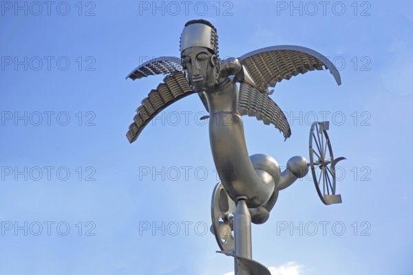 Sculpture Birdman by Albert Sous, modern art, abstract art, stainless steel, metal sculpture, whimsical bizarre bird figure, mythical creature, hybrid creature, wings, flying, wheel, cut-out, detail, Bastinsweiher, Rhineland, Stolberg, North Rhine-Westphalia, Germany