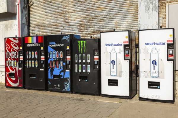Row of popular bottled cold soft drinks and mineral water brands for sell in vending machines on promenade in Old Port of Montreal, Quebec, Canada