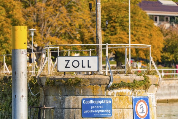 Small customs station on the shore with railings and signs in autumnal surroundings, Meersburg, Lake Constance, Germany