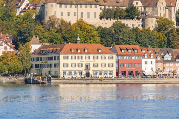 Historic buildings on the lakeshore with autumnal vegetation in the background, Meersburg, Lake Constance, Germany