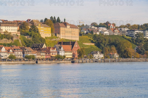 Houses along the lakeshore, surrounded by autumnal trees and hills, Meersburg, Lake Constance, Germany