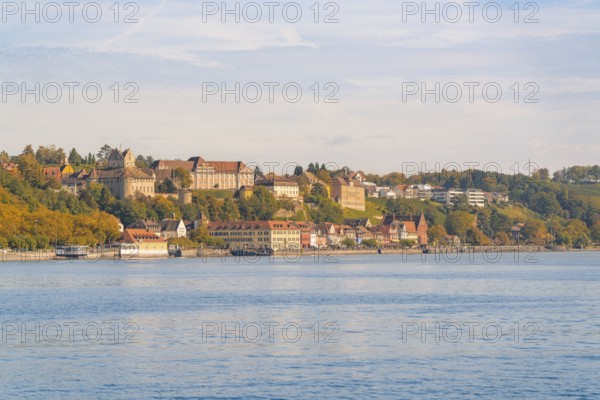 Town view on the lakeshore with historic buildings and autumnal trees under a blue sky, Meersburg, Lake Constance, Germany