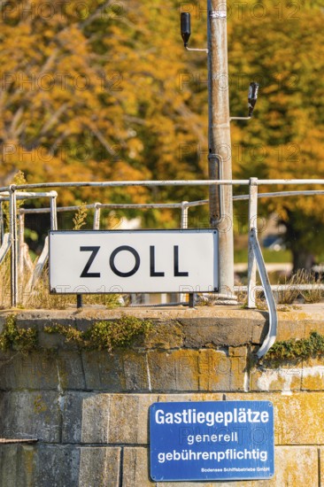 Close-up of a customs sign with autumn leaves in the background, Meersburg, Lake Constance, Germany