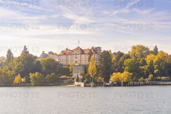 Castle surrounded by autumn trees on the lake under a blue sky, Mainau Island, Lake Constance, Germany