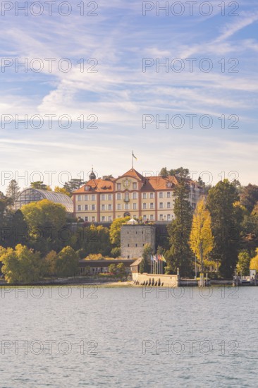 Historic castle with tower on the lakeshore surrounded by autumn trees, Mainau Island, Lake Constance, Germany