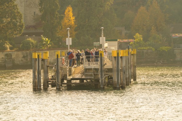 Group of people gathering on a jetty in sunny autumn weather, Mainau Island, Lake Constance, Germany