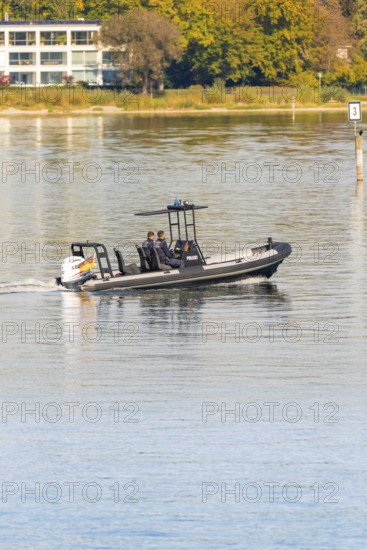 People in a police motorboat gliding across the calm lake on a sunny day, Constance, Lake Constance, Germany