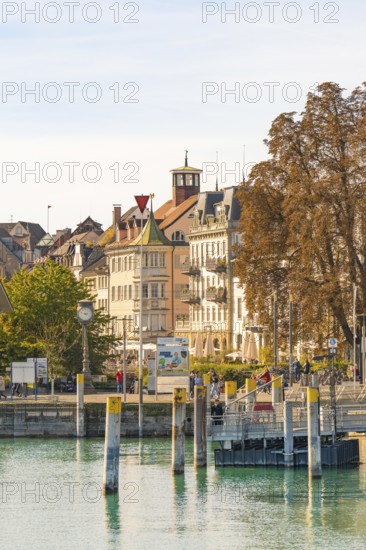 City view with historic buildings, clock tower and modern harbour area on a calm water, Constance, Lake Constance, Germany