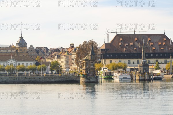 Historic harbour view with boats and buildings at calm lake and autumn atmosphere, Constance, Lake Constance, Germany