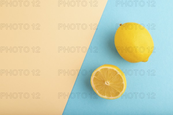 Yellow Lemon Cut in half on orange and blue pastel paper background. Top view, flat lay, copy space. healthy food, vegetable, minimalism