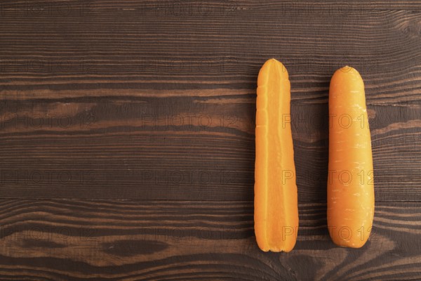 Orange Carrot on brown wooden background. Top view, copy space, flat lay. healthy food, vegetable, minimalism